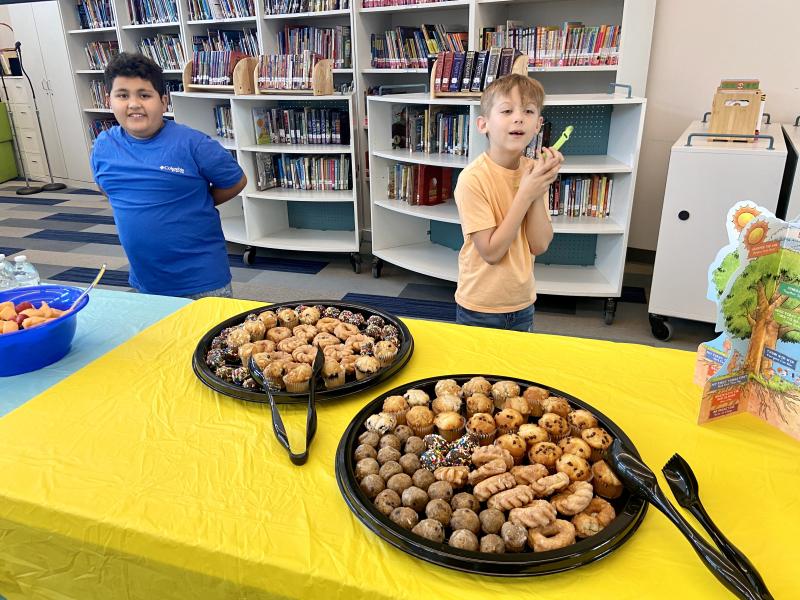 First-graders Juan Galvez, left, and EJ Rossiter are ready to help serve a continental breakfast to guests.